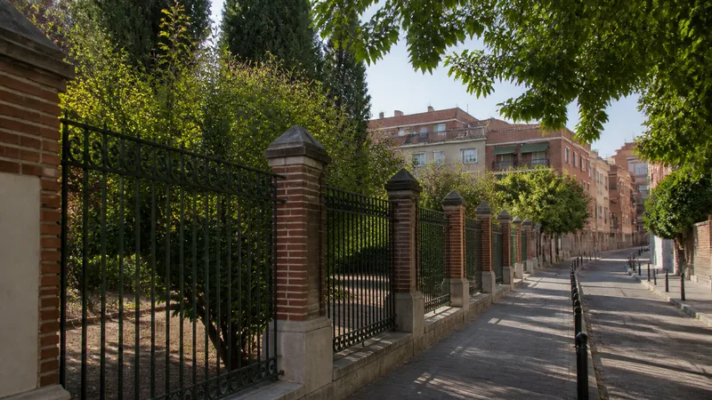 Verja histórica y edificios de ladrillo en una escena urbana genérica inspirada en Carabanchel