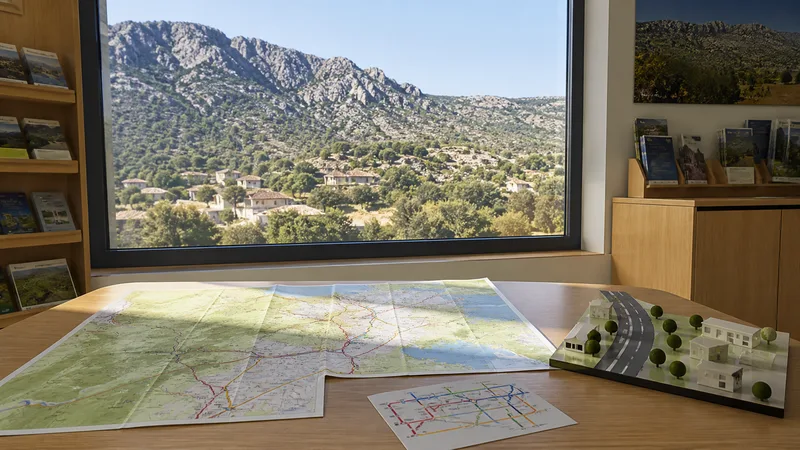 Centro de información rural genérico y vacío con mapas sin texto legible y un paisaje serrano al fondo