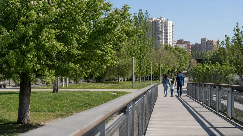 Familia vista de espaldas caminando por Madrid Río con amplias zonas verdes