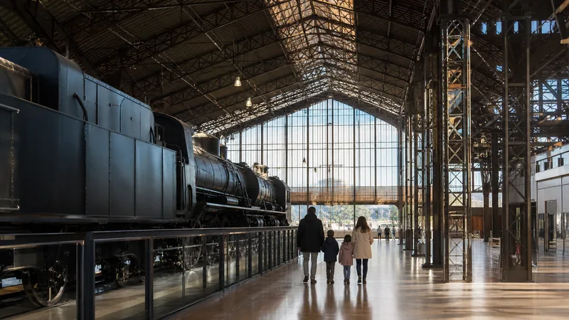 Familia observando una locomotora histórica en una nave ferroviaria