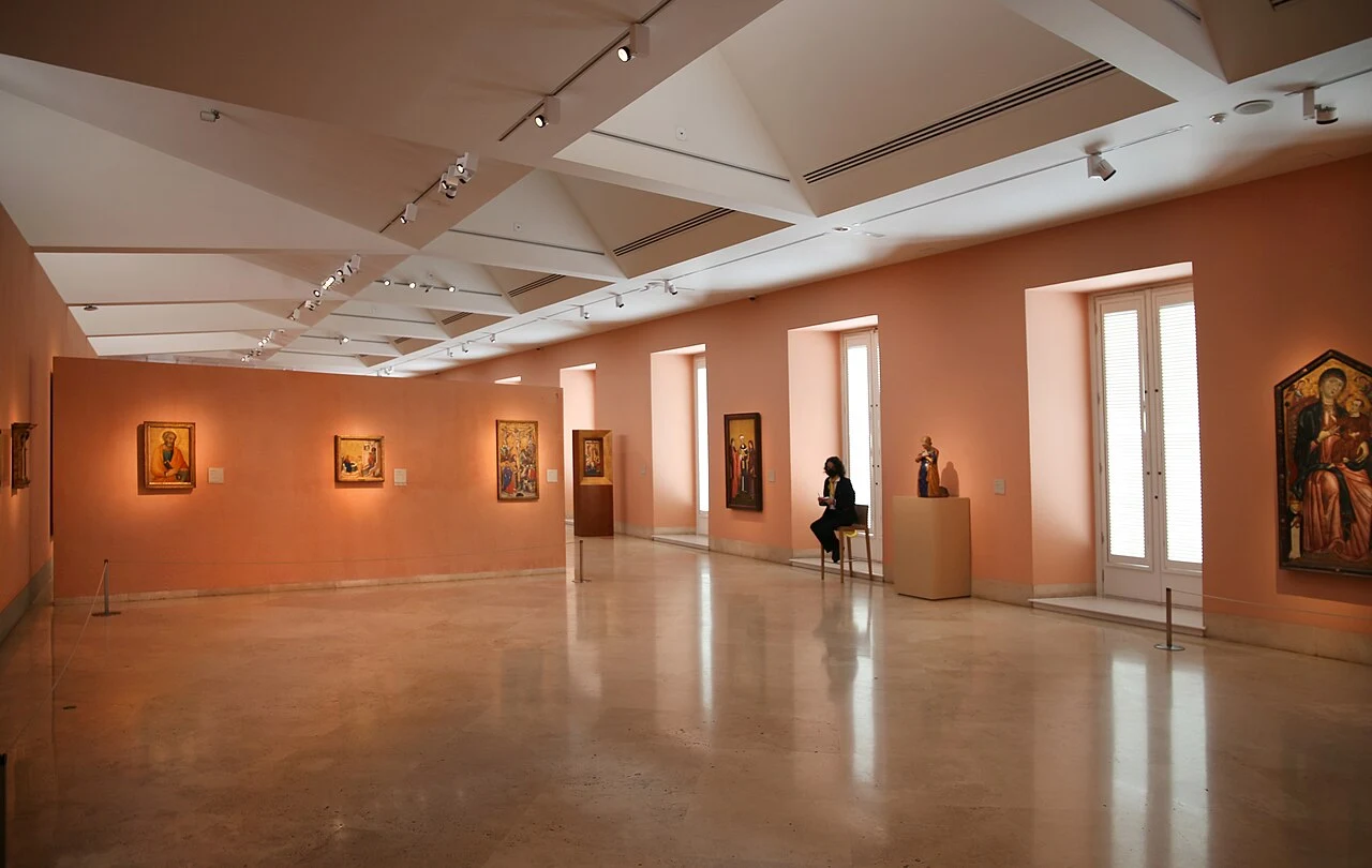Sala de pintura antigua del Thyssen con paredes de color salmón y luz natural