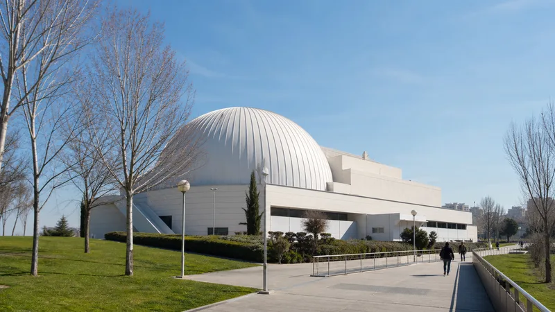 Cúpula blanca de un planetario rodeada por senderos y zonas verdes