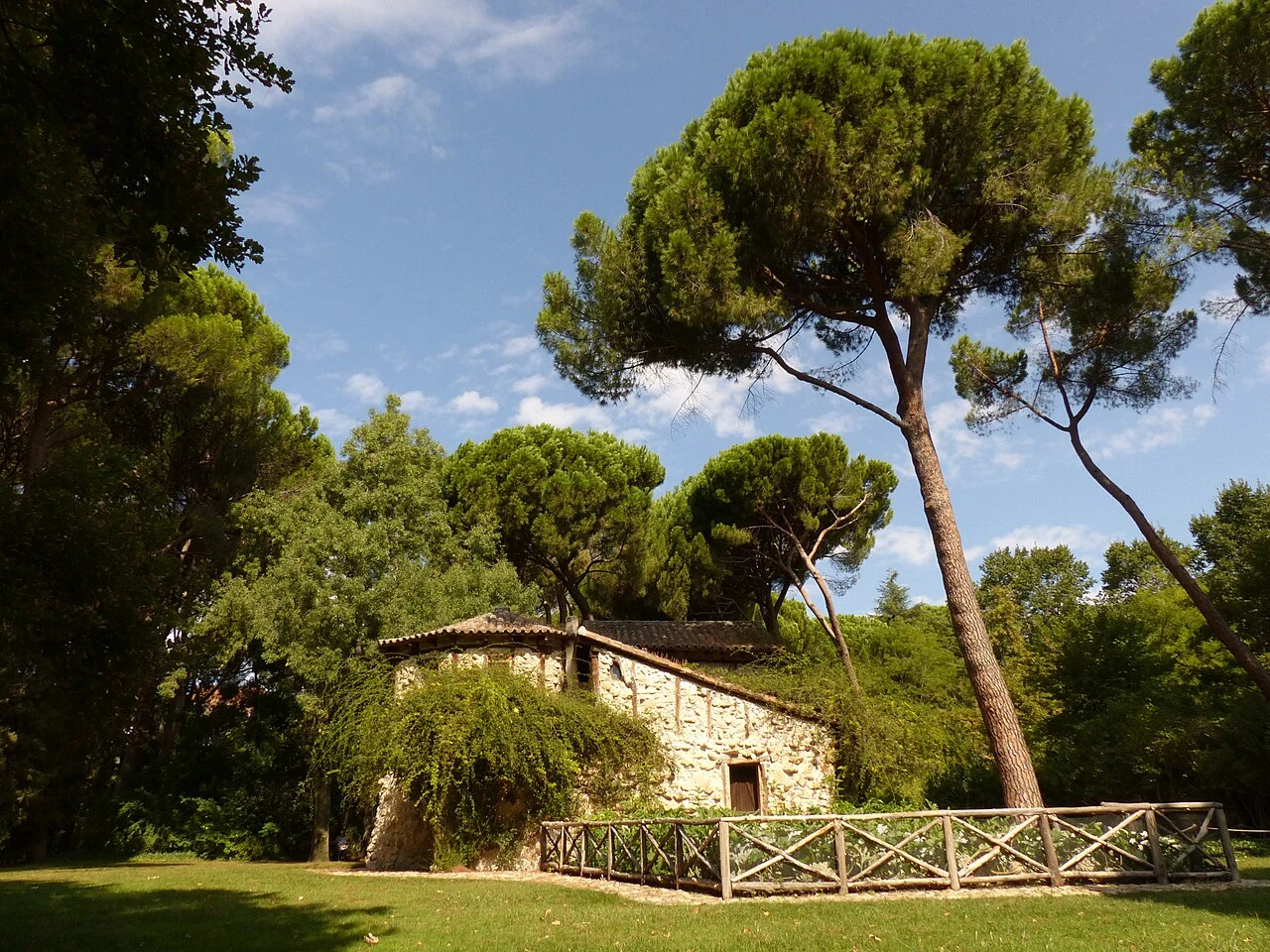 Casa de la Vieja entre pinos y vegetación del jardín de El Capricho