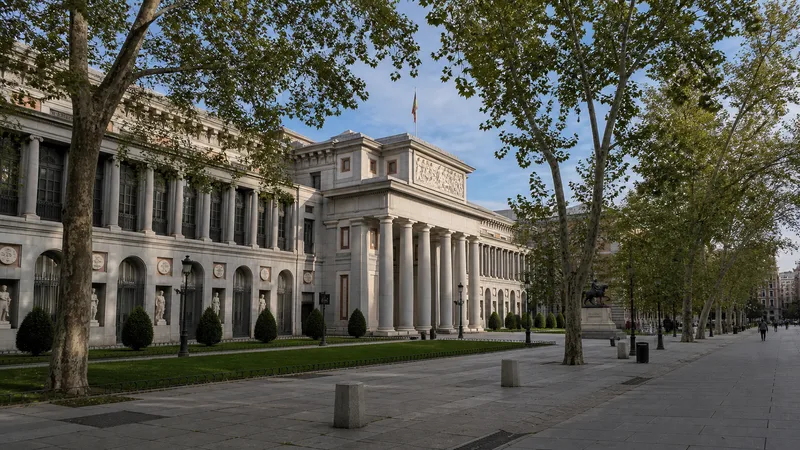 Fachada neoclásica del Museo del Prado bajo los árboles del paseo