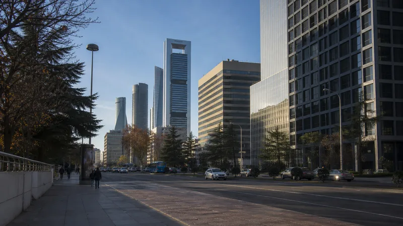Paseo de la Castellana con edificios de oficinas y torres al fondo