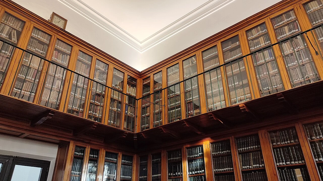 Estanterías de madera y libros de la biblioteca histórica del Observatorio