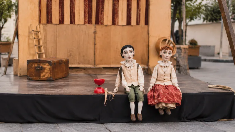 Dos títeres y un diábolo sobre un pequeño escenario de calle